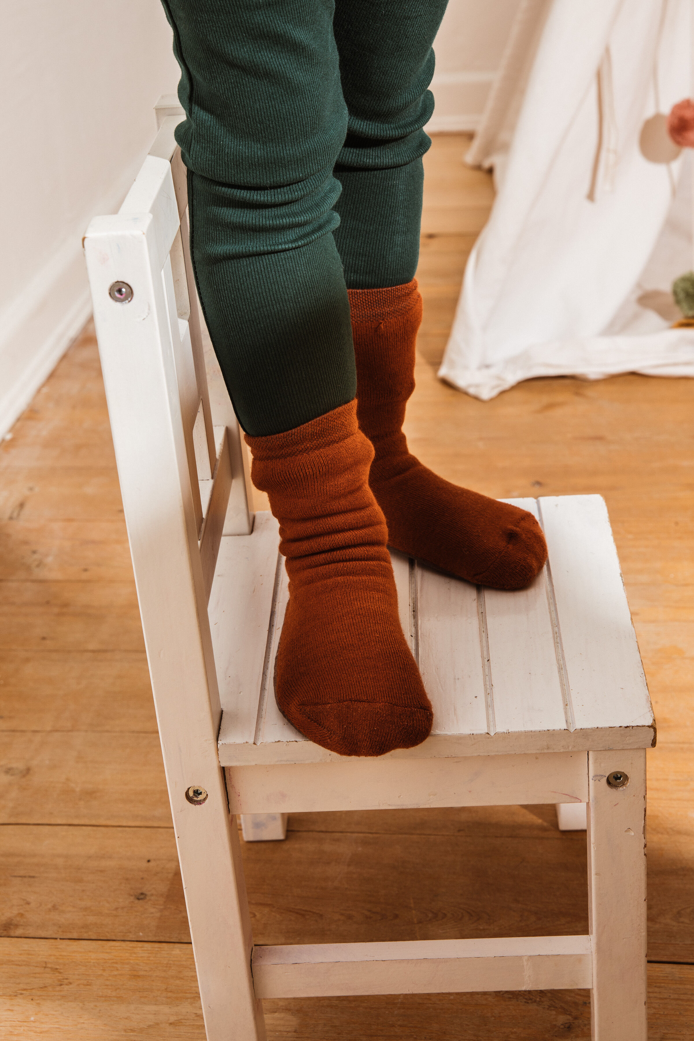Stopper Junge Junge auf Stuhl stehend mit Stoppersocken SoftStep in Kupfer