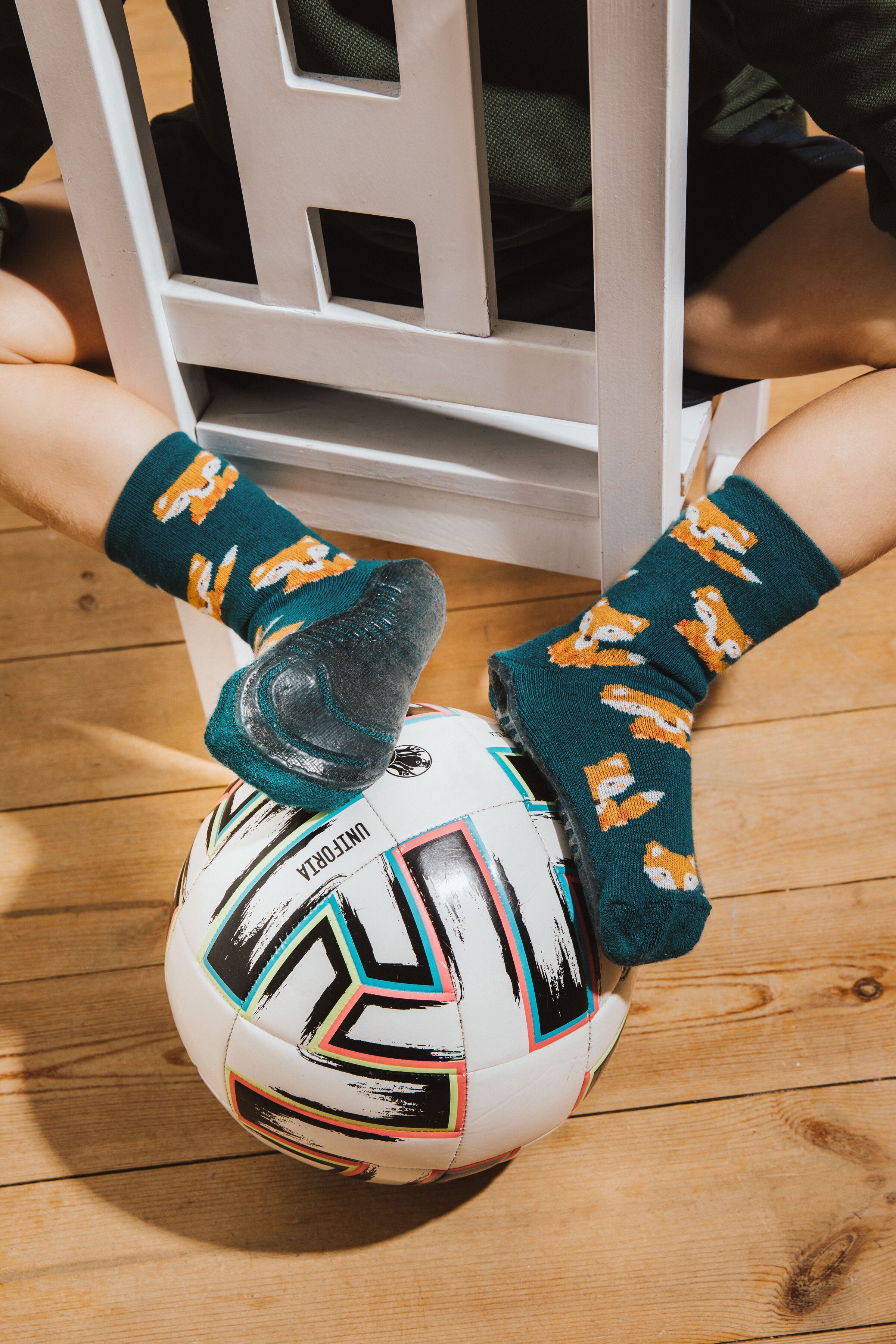 Stopper Fuchs Junge auf Stuhl sitzend mit Fußball und Stoppersocken SoftStep Grün mit Fuchsmotiv